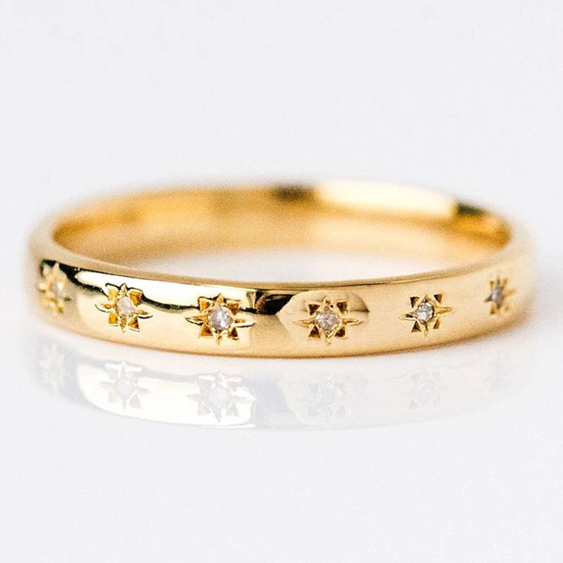 Anello placcato oro con dettagli in zirconio e incisioni a stella